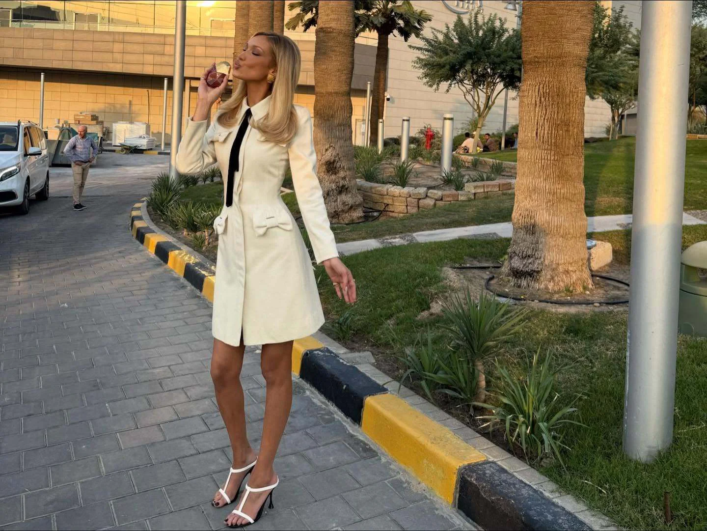 Elegant Cream Coat with Black Accents and Strappy Sandals for a Sophisticated Look