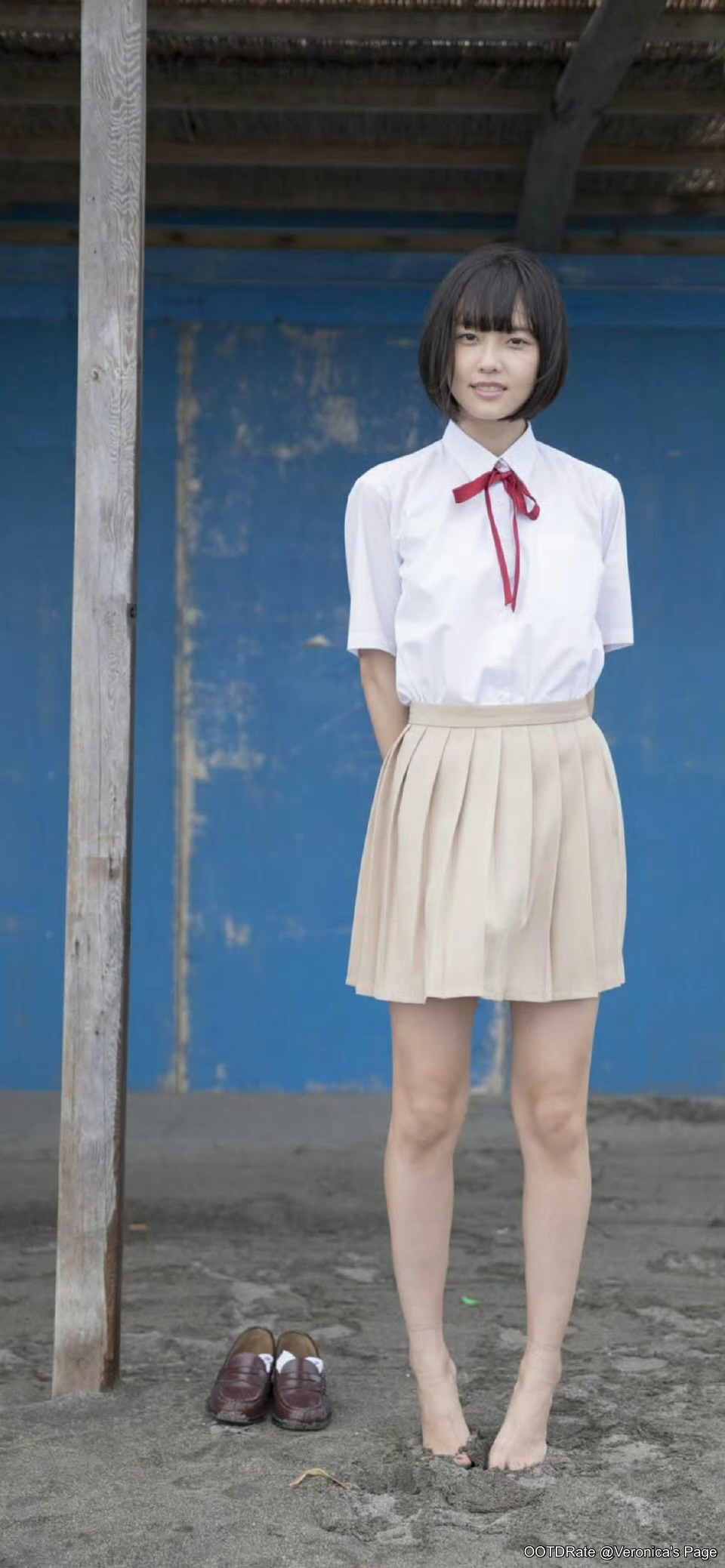 Classic Schoolgirl Style with White Blouse, Beige Pleated Skirt, and Red Bow