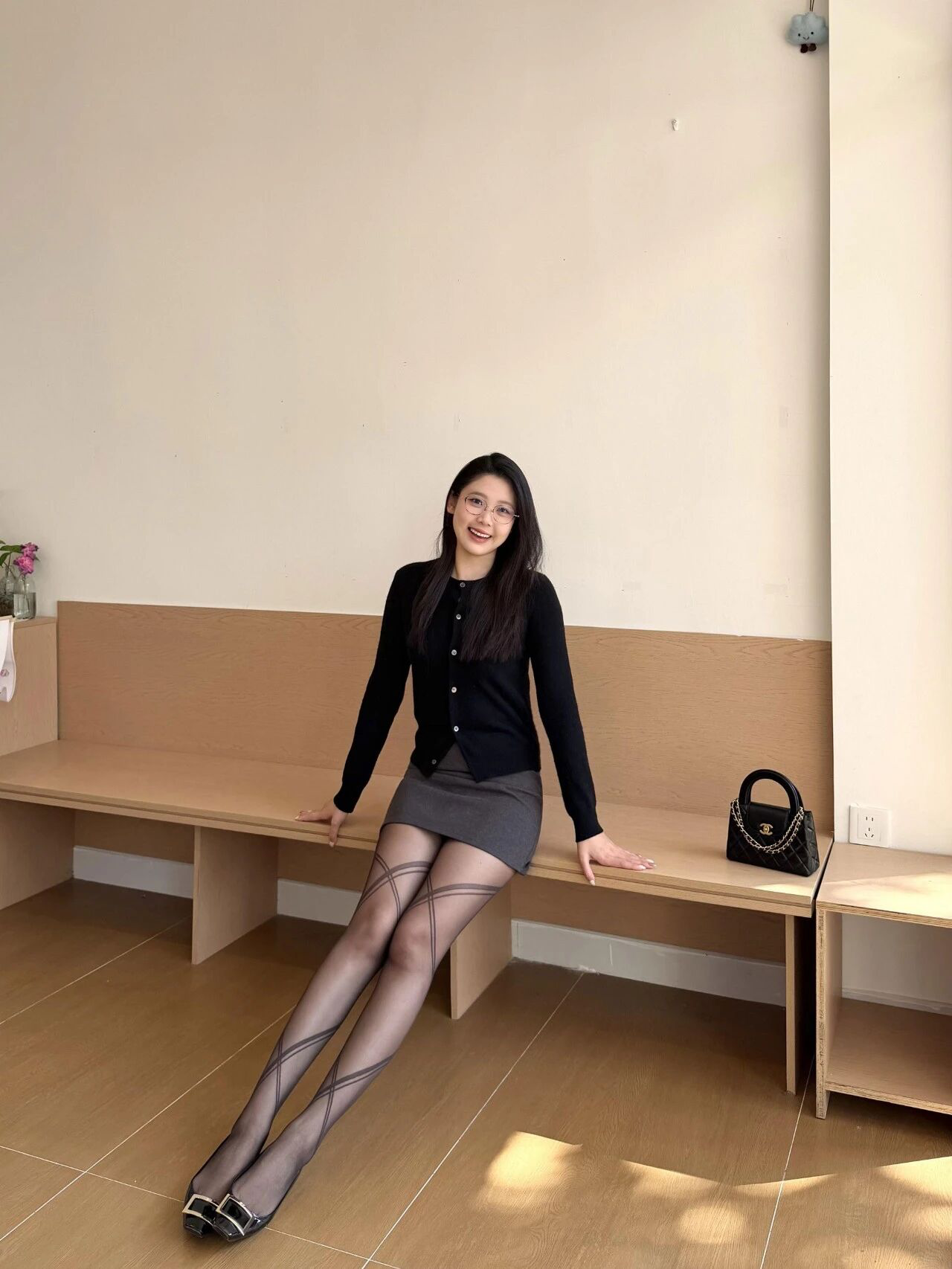 Chic Black Cardigan with Gray Skirt and Patterned Tights for a Modern Look