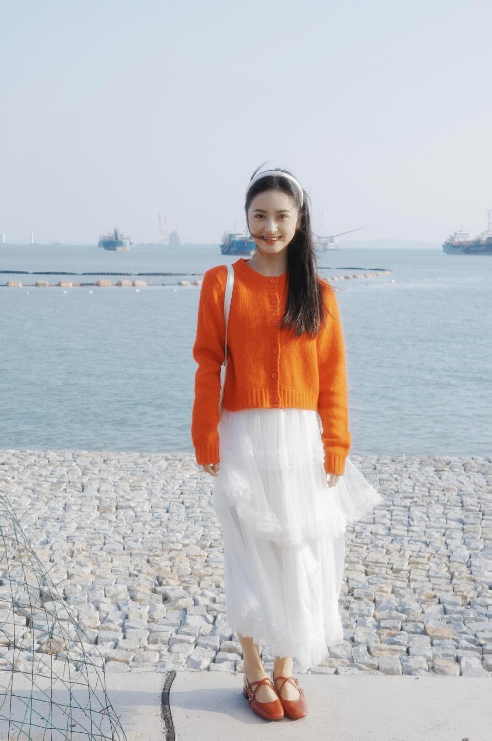 Vibrant Orange Cardigan Paired with Layered White Dress for a Refreshing Casual Look