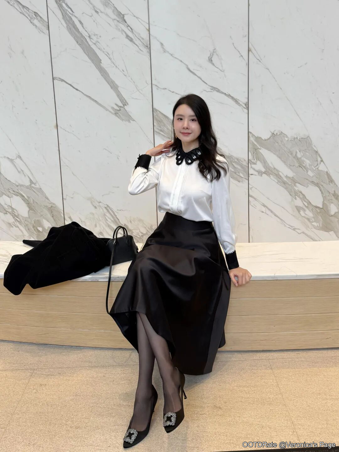 Monochrome Elegance: White Blouse with Black Satin Skirt and Embellished Heels