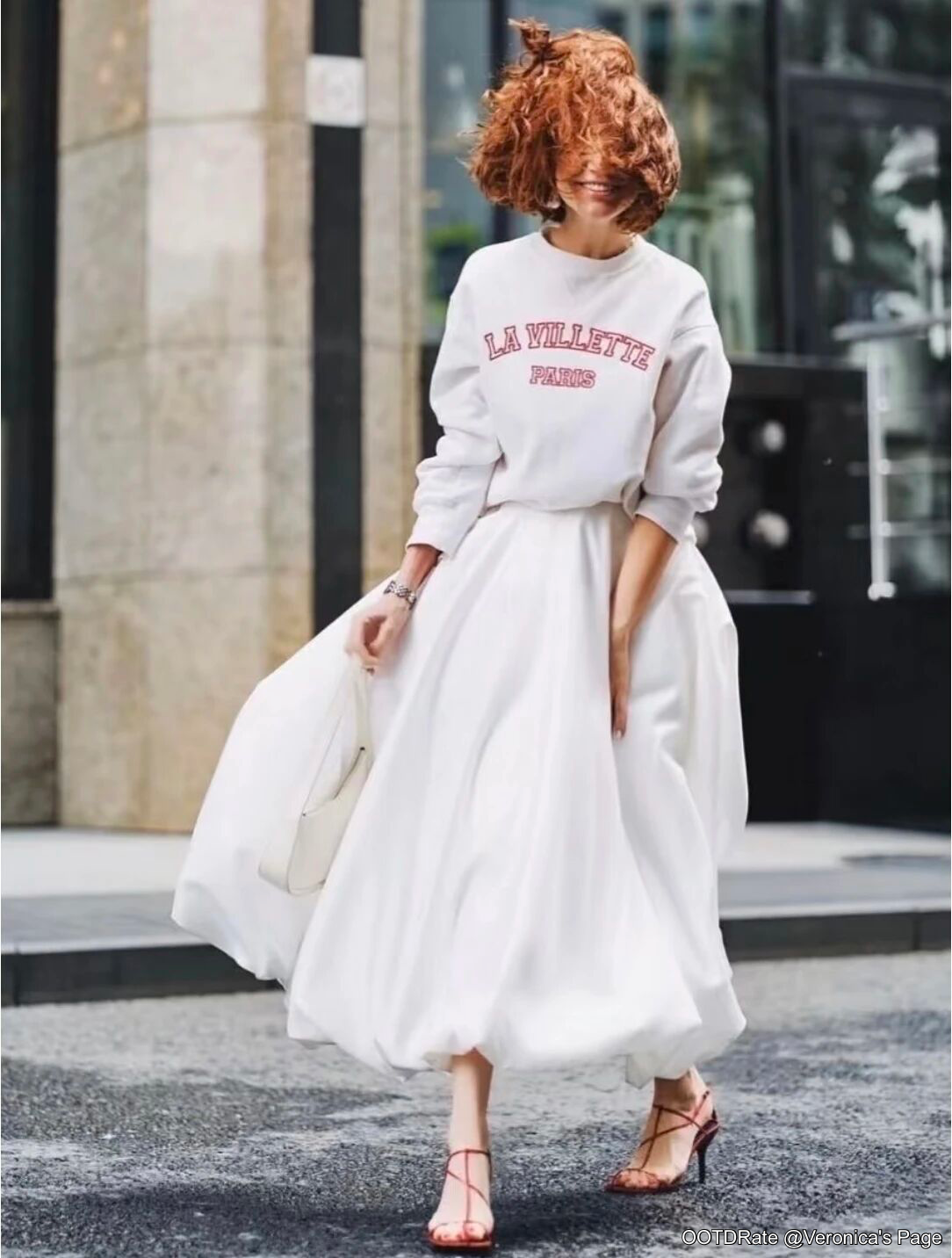 Chic Contrast: Graphic Sweatshirt Paired with Flowing White Skirt and Red Sandals