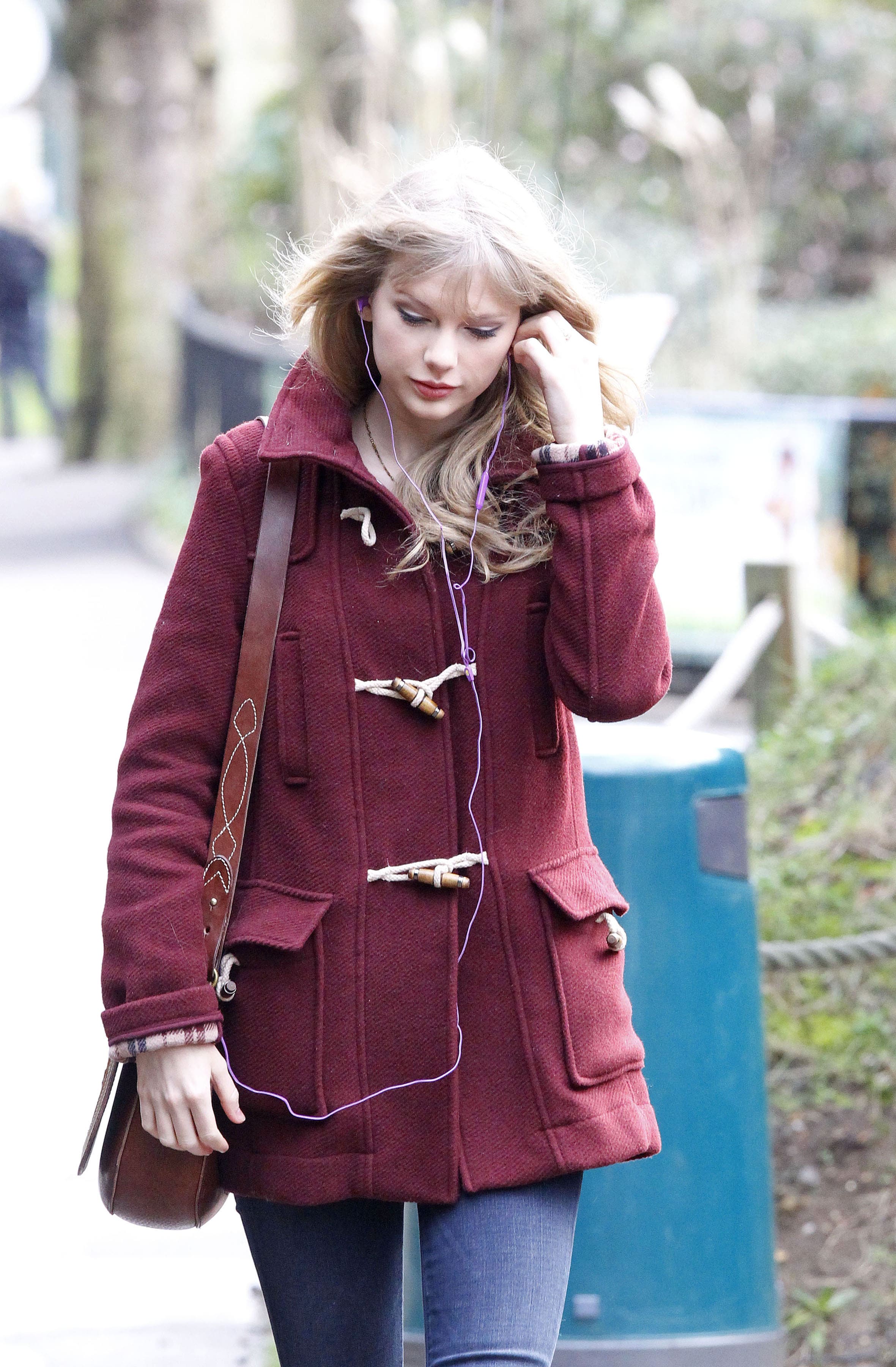 Taylor Swift in burgundy toggle coat and blue jeans