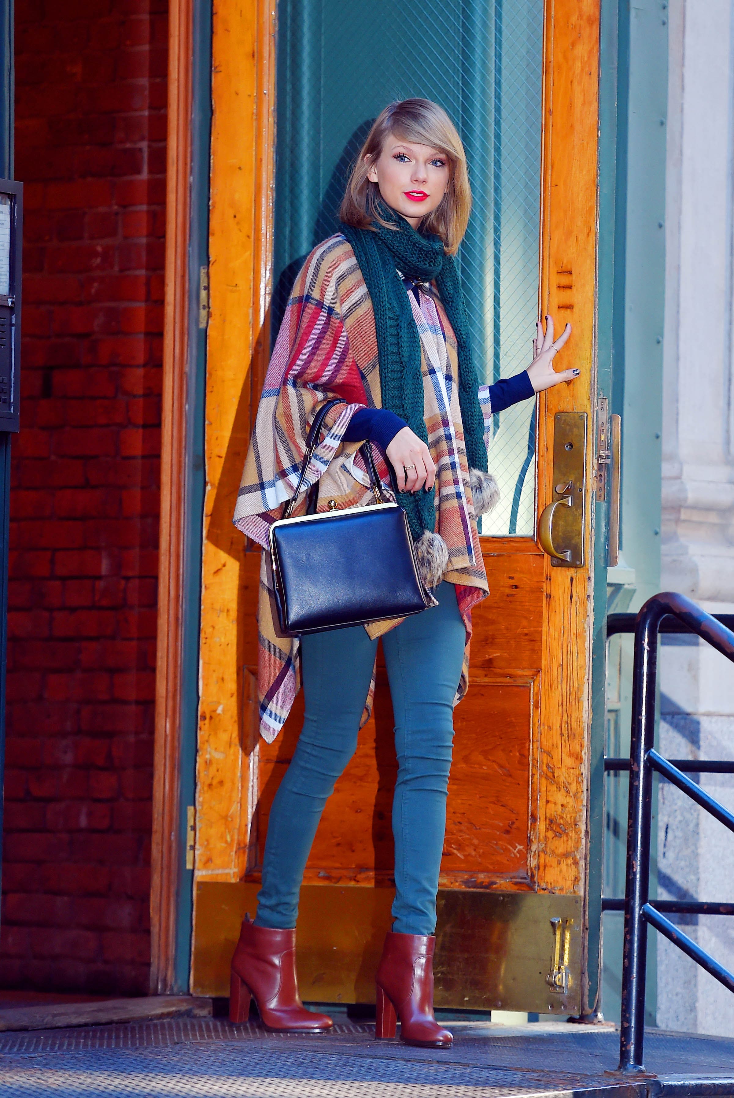 Taylor Swift in plaid shawl with green jeans and burgundy boots
